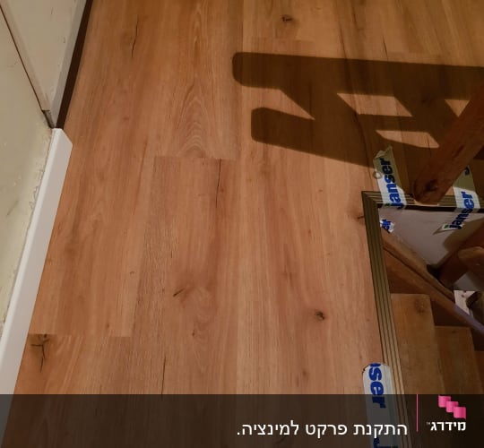 רצפת פרקט עץ עם גימור בהיר ופסי חיבור
